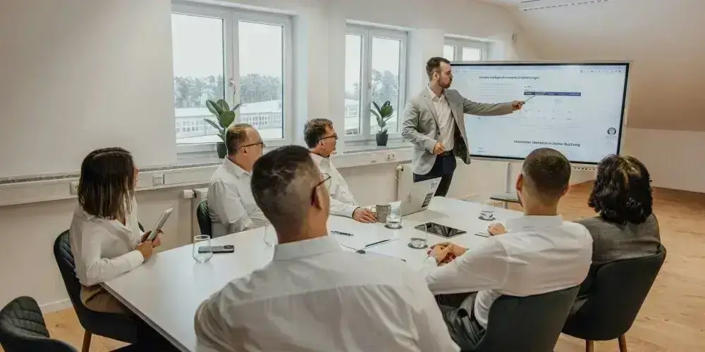 A business professional leading a presentation in a meeting room with attentive team members, symbolizing focus and collaboration in a mindful work environment.